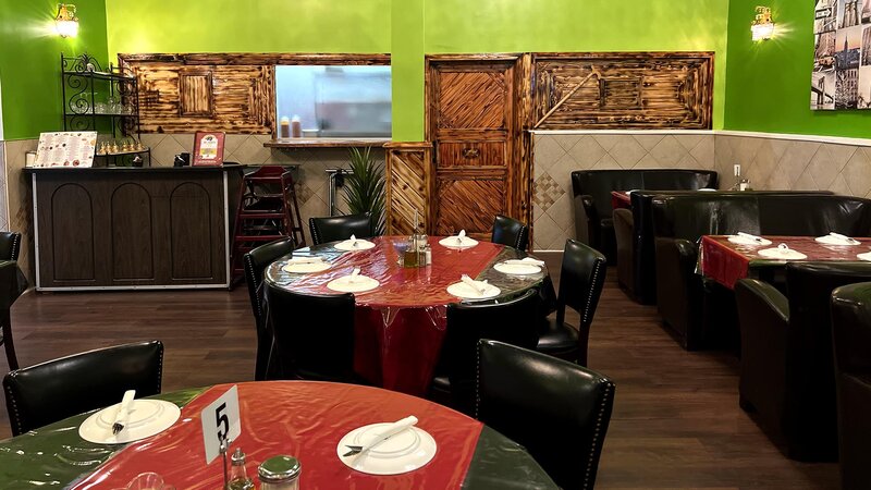Restaurant dining room with set tables and view of pick up counter